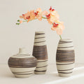 Three decorative vases with striped patterns on a light background