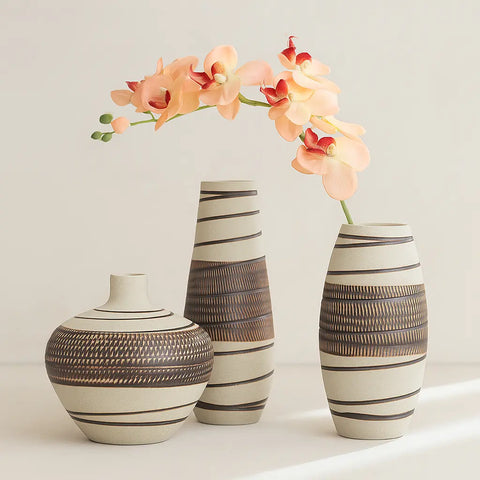 Three decorative vases with striped patterns on a light background