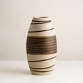 Ceramic vase with black patterns on a plain background