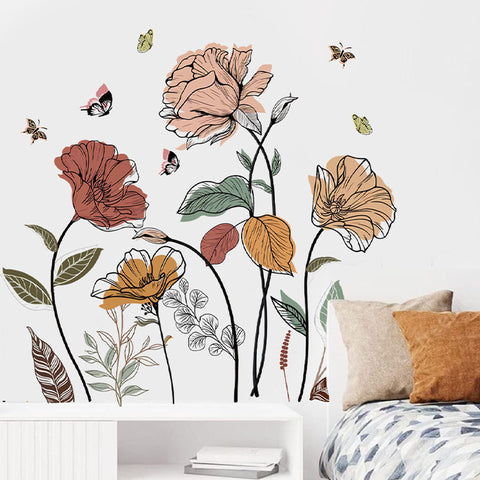 Floral wall decals on a white wall with a bed and pillows in the foreground.