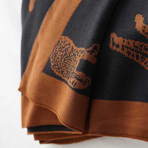 Brown and black patterned fabric with animal designs on a white background