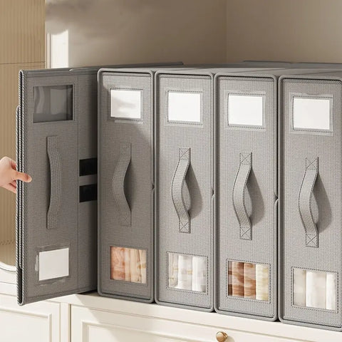 Set of gray fabric storage boxes with handles on a white surface.