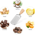 Collection of ingredients including coconut, lemon, ginger, chocolate, cheese, and nuts with a grater in the center.