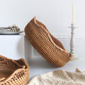 Woven baskets on a white surface with a candle and decorative items.