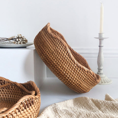 Woven baskets on a white surface with a candle and decorative items.