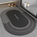 Black bath mat with 'HOME' text on a bathroom floor