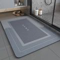 Blue gray non slip bath mat with 'HOME' text on a bathroom floor
