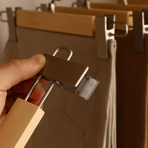 Hand holding a wooden clip with metal clip against a blurred background
