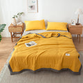 Yellow quilt summer blanket on a bed in a bedroom with wooden nightstands and decor.