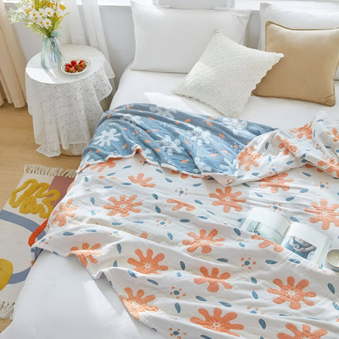 Close-up of abstract sunny reversible blanket showing vibrant coral and azure patterns on soft cotton fabric.