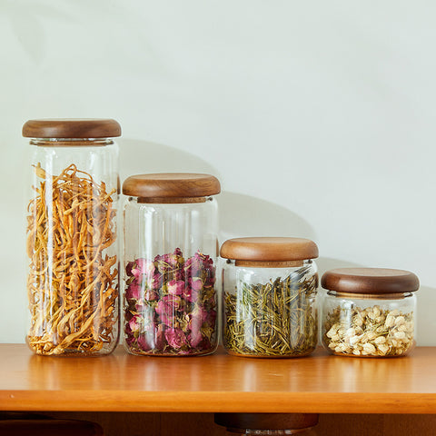 Full Acacia glass kitchen storage jar set filled with dried goods displayed on a shelf