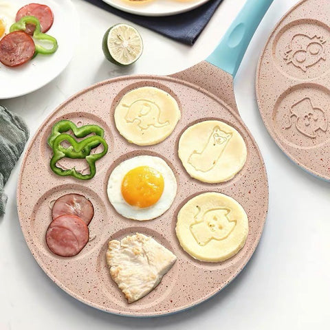 Animals waffle and pancake pan with blue handle cooking pancakes with animal shapes, fried egg, chicken slice, bell pepper, and sliced meat on white plate background