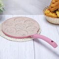 Animals waffle and pancake pan with pink handle placed on braided white coaster on light wood table with bread basket nearby