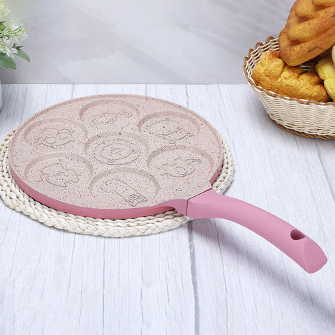 Animals waffle and pancake pan with pink handle placed on braided white coaster on light wood table with bread basket nearby