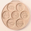 Top view of pink Animals Waffle and Pancake Pan showing playful animal smiley face molds on a neutral background