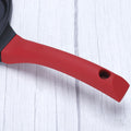Close-up of red handle on Animals Waffle and Pancake Pan on white wooden surface