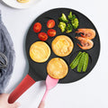 Animals waffle and pancake pan with red handle serving pancakes with a pink spatula, cooked pancakes and fresh vegetables on white table