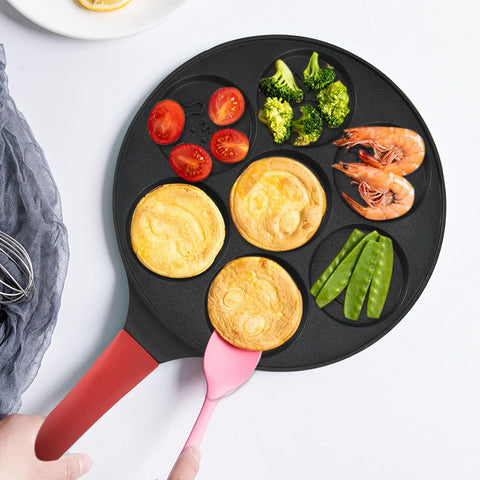 Animals waffle and pancake pan with red handle serving pancakes with a pink spatula, cooked pancakes and fresh vegetables on white table