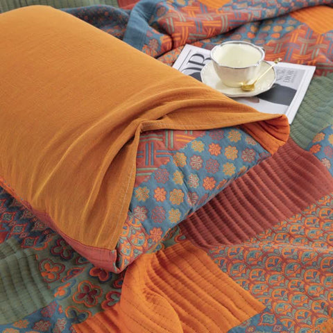 Laid-out quilt and pillows in cozy bedroom lighting