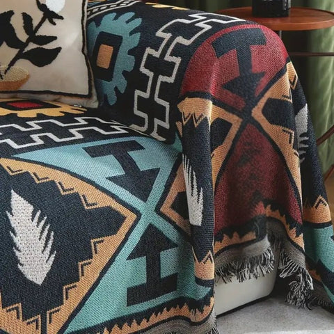 Close-up of Aztec geometric sofa throw showing detailed tribal print and tassel finish.