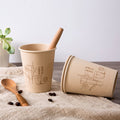 Stack of bamboo fiber eco cups with coffee on linen
