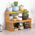 Bamboo kitchen spice rack used as a two-tier plant display stand with flower pots