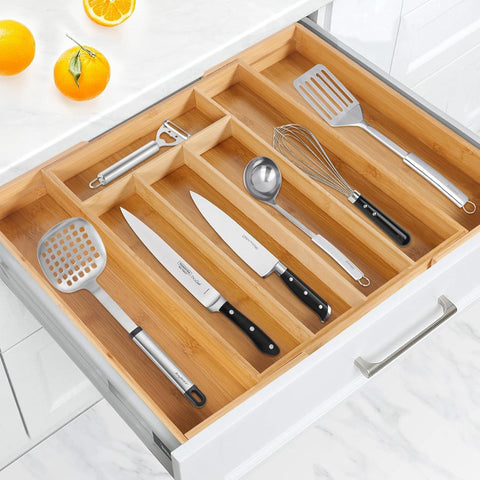 Wooden kitchen utensil organizer with cutlery on a white cabinet background
