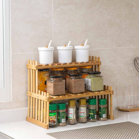 Bamboo spice rack on kitchen counter holding jars and condiments on two shelves