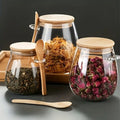 Glass jars with wooden lids and spoons containing various herbs and spices on a dark background