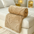 Beige butterfly embossed fleece throw blanket on bed – cozy and decorative couch cover
