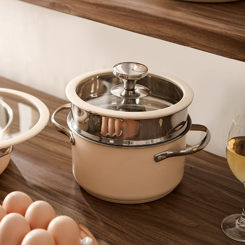 Steamer pot and saucepan from beige cookware set in use on counter