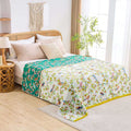 Cozy Birdsong cotton throw blanket with colorful bird and leaf pattern draped over bed in bright bedroom setting