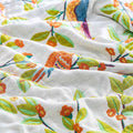  Close-up of birdsong cotton throw blanket showing colorful bird and floral embroidery on soft white cotton fabric