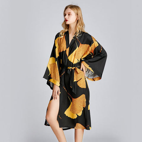 Luxury black satin kimono robe with golden ginkgo leaf print, long sleeves, and adjustable belt—elegant loungewear for home, spa, or resort wear.