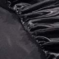 Close-up of elastic corner on luxury black satin fitted bed sheet