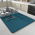 Blue absorbent dish mat in modern kitchen setup with cups and forks