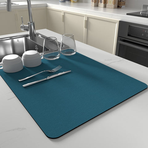 Blue absorbent dish mat in modern kitchen setup with cups and forks