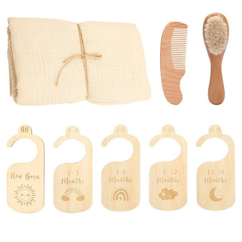 Baby care set with muslin cloth, comb, brush, and growth chart markers on a white background
