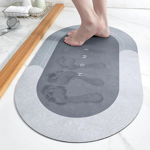 Blue non-slip bath mat with visible wet footprints and modern oval design