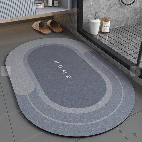 Blue oval non-slip bath mat placed near shower with modern tile design.