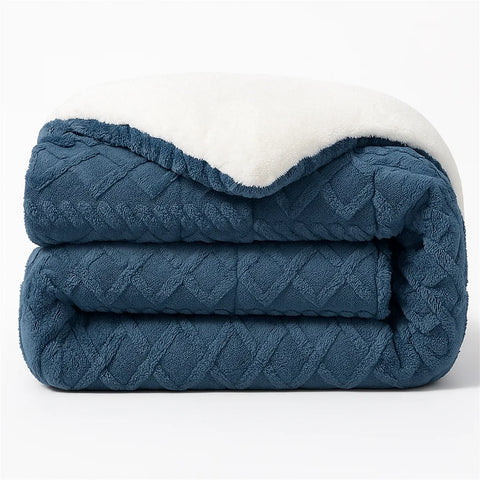 Folded blue textured blanket with white interior on a light gray background