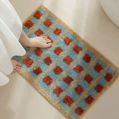 Foot stepping on soft Moroccan bath mat with vintage red and blue pattern