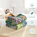 Folded bohemian floral cotton throw blanket on bedside table highlighting skin-friendly, machine washable, and fade-resistant features