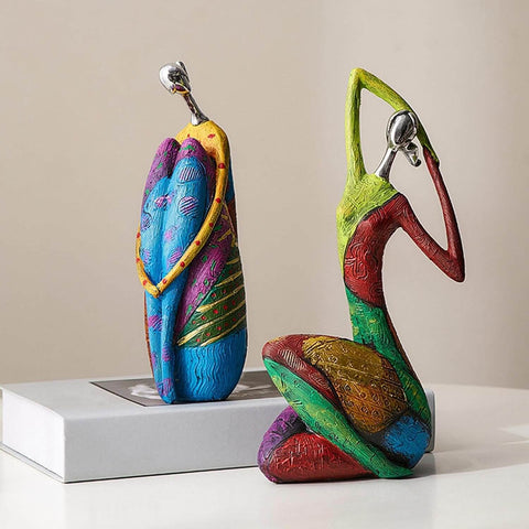 Colorful ceramic figures on a white surface with a beige background