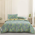 Full bed dressed in green botanical quilt with pillow shams, styled with minimalist decor