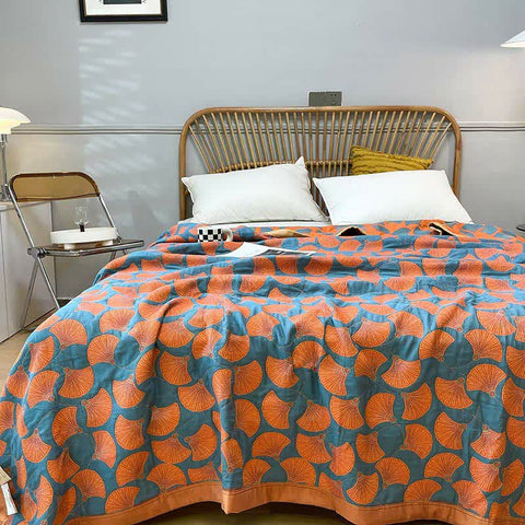 Orange and blue cotton quilt styled on bed