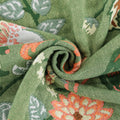 Close-up of green fabric with floral patterns Soft cotton gauze blanket rolled to show texture
