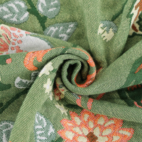 Close-up of green fabric with floral patterns Soft cotton gauze blanket rolled to show texture