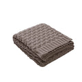 Folded brown knitted blanket on a white background