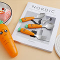 Playful kids carrot cutlery laid on book and table